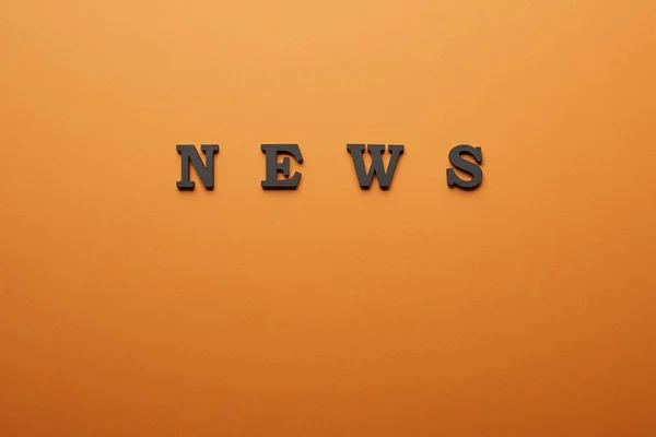 Top view of news lettering with copy space on orange — Stock Photo