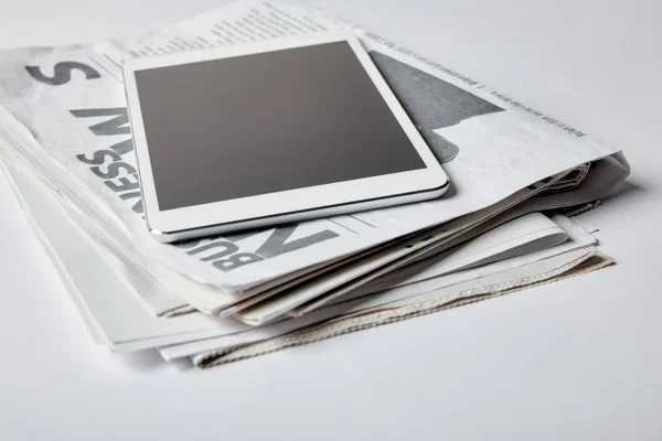 Digital tablet with blank screen near business newspapers on white — Stock Photo