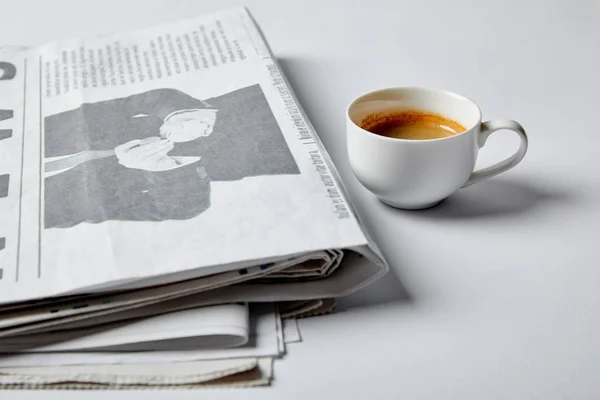 Selektiver Fokus der Tasse mit Kaffee in der Nähe von Zeitungen auf weiß — Stockfoto