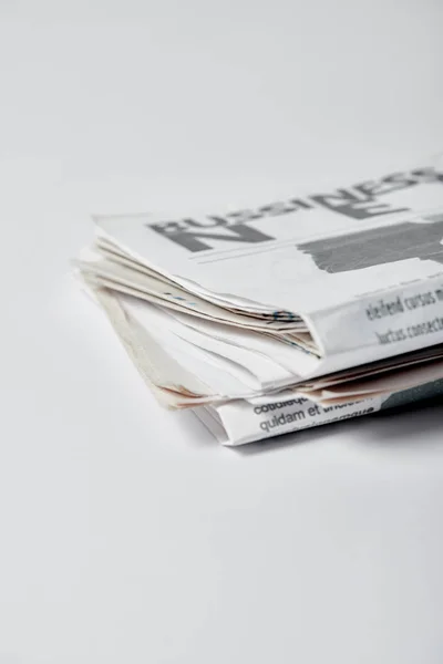 Selective focus of business newspapers with lettering on white — Stock Photo