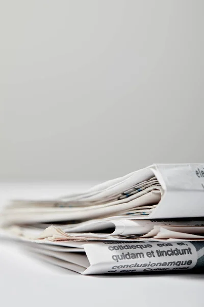 Selective focus of newspapers with lettering and copy space on grey — Stock Photo