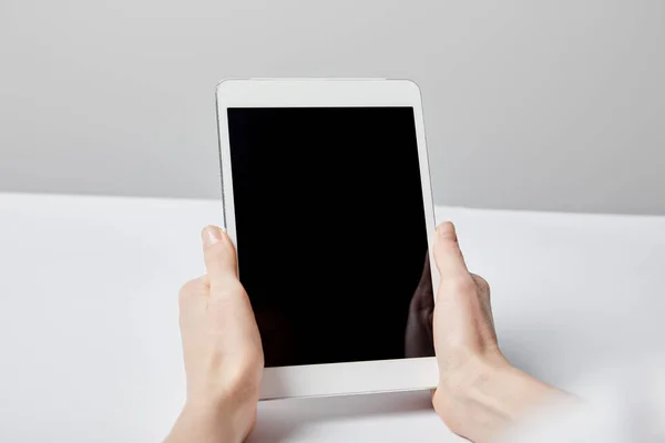 Vista ritagliata della donna con tablet digitale con schermo bianco sul grigio — Foto stock