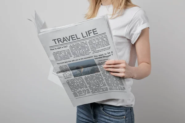 Cropped view of woman reading travel newspapers isolated on grey — Stock Photo