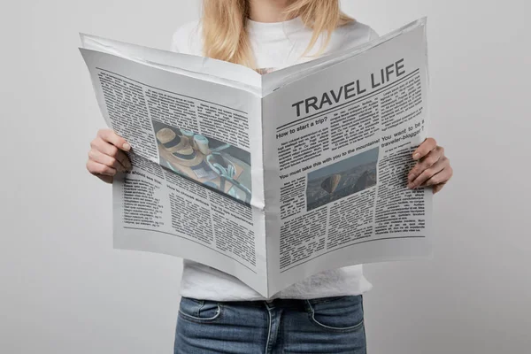 Cropped view of woman holding travel newspapers isolated on grey — Stock Photo