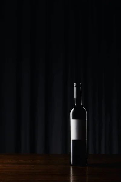 Пляшка вина з порожньою етикеткою на дерев'яній поверхні — стокове фото