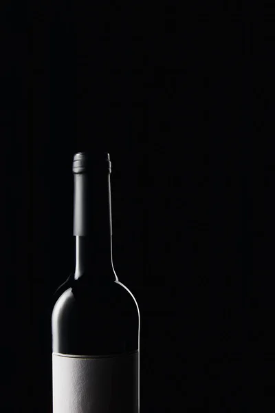 Glasweinflasche mit leerem Etikett isoliert auf schwarz — Stockfoto
