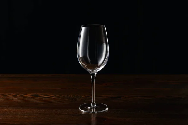 Bicchiere di vino vuoto su superficie di legno isolato su nero — Foto stock