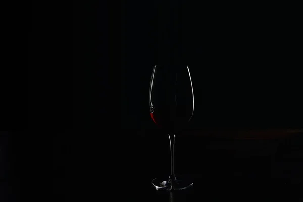 Silhouette of glass of burgundy red wine on black — Stock Photo