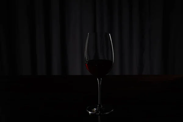 Silhouette of glass with burgundy red wine on dark — Stock Photo