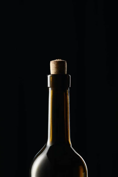 Garrafa de vinho de vidro com cortiça de madeira isolada em preto — Fotografia de Stock