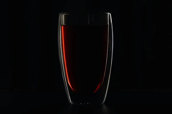 Glass full of burgundy red wine on black — Stock Photo