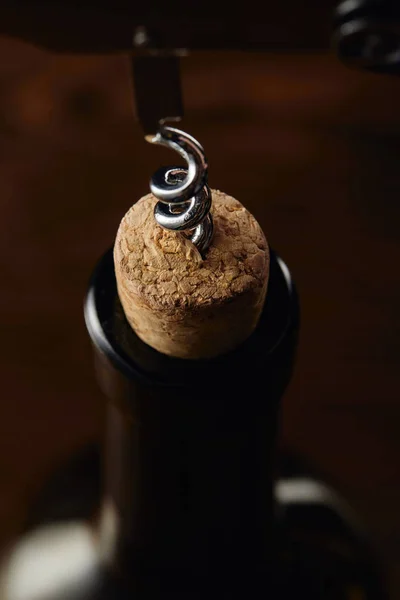 Botella de vino con corcho de madera y sacacorchos en marrón - foto de stock