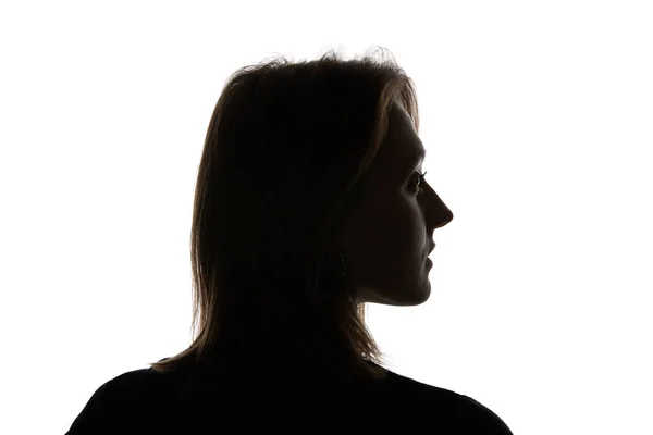 Silueta de mujer joven mirando hacia otro lado aislada en blanco - foto de stock