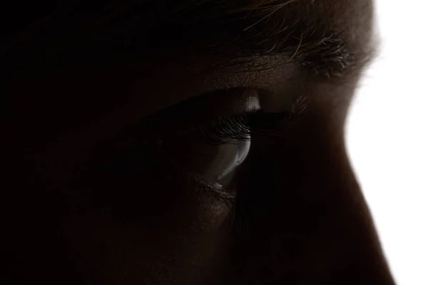 Close up view of woman looking away in darkness on white — Stock Photo