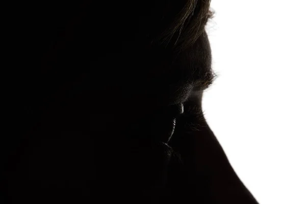 Vista da vicino della donna che distoglie lo sguardo nel buio sul bianco — Foto stock