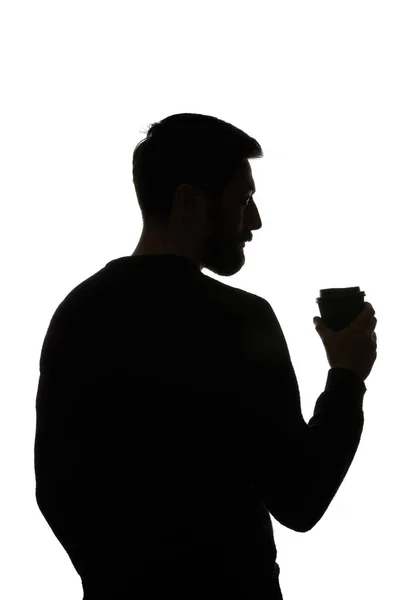 Silhouette of man holding paper cup of coffee isolated on white — Stock Photo