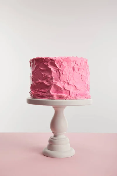 Dolce torta di compleanno rosa sul supporto torta isolato su grigio — Foto stock