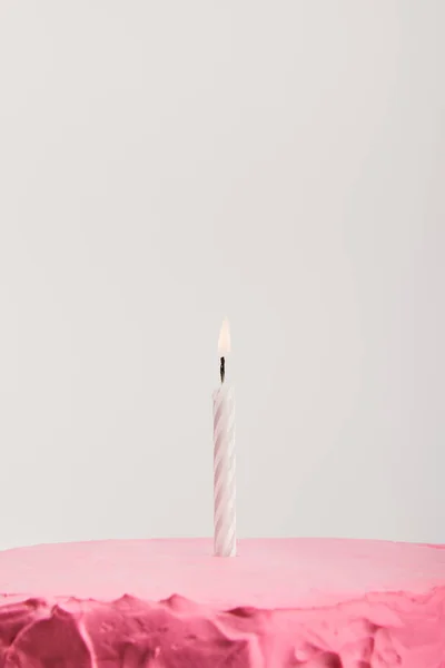 Gros plan de bougie sur délicieux gâteau d'anniversaire rose isolé sur gris — Photo de stock