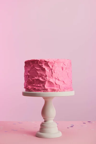 Delicious pink birthday cake on cake stand isolated on pink — Stock Photo