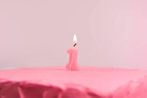 Selective focus of burning number one candle on pink and tasty birthday cake isolated on pink — Stock Photo