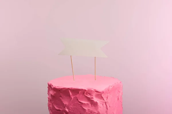 Pink sweet birthday cake with blank card isolated on pink — Stock Photo
