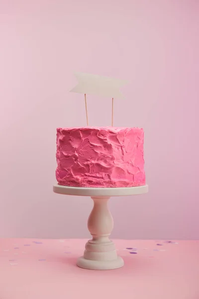 Tasty and sweet birthday cake with blank card on pink — Stock Photo