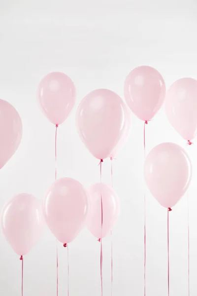 Sfondo con palloncini d'aria rosa galleggianti festivi su bianco — Foto stock