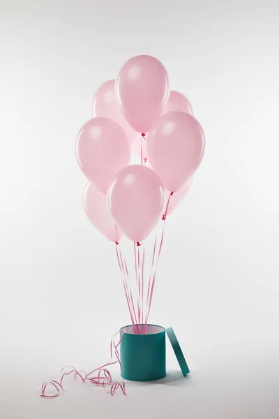 Bündel rosa Luftballons mit türkisfarbenem Geschenkkarton auf weißem Grund — Stockfoto