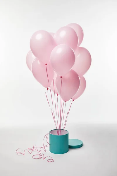 Fascio di palloncini rosa decorativi con scatola regalo turchese su bianco — Foto stock