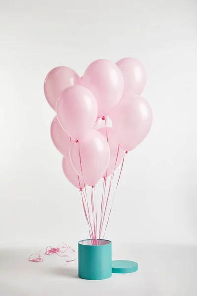 Pacchetto di palloncini rosa festivo aria con scatola regalo turchese su bianco — Foto stock