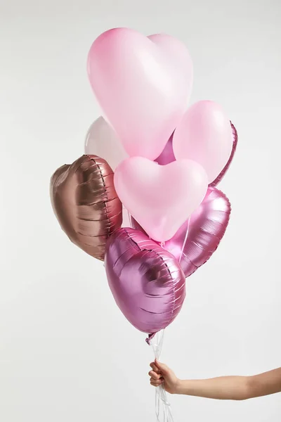Cropped view of girl holding heart-shaped pink air balloons isolated on white — Stock Photo