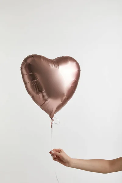 Vista cortada da menina segurando balão de ar dourado em forma de coração isolado no branco — Fotografia de Stock