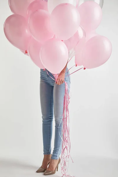 Cropped of girl in denim holding pink air balloons on white — Stock Photo