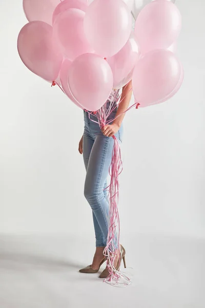 Cropped of girl in denim holding pink air balloons on white — Stock Photo
