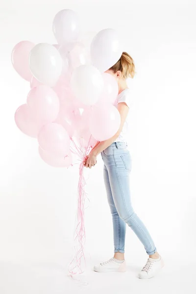 Fille en vêtements décontractés couvrant visage avec des ballons à air rose isolé sur blanc — Photo de stock