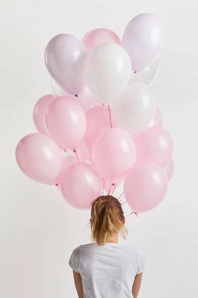 Back view of girl holding pink air balloons isolated on white — Stock Photo