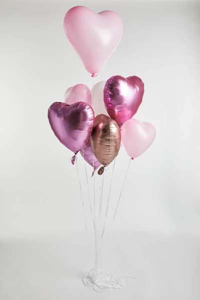 Fascio di palloncini festivi rosa e dorati a forma di cuore su bianco — Foto stock