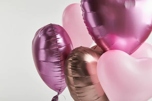 Herzförmige rosa und goldene festliche Luftballons auf weißem Grund — Stockfoto