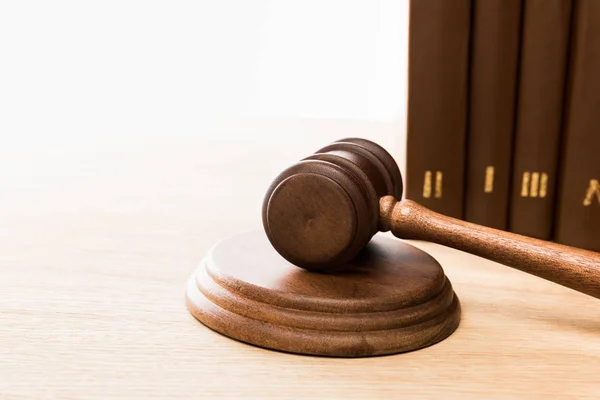 Selective focus of brown gavel and books on wooden table isolated on white — Stock Photo