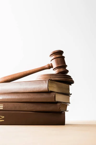 Bottom view of gavel on pile of brown books on wooden table isolated on white — Stock Photo