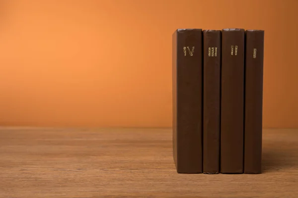 Volumi di libri d'epoca in pelle marrone copertine su tavolo in legno — Foto stock