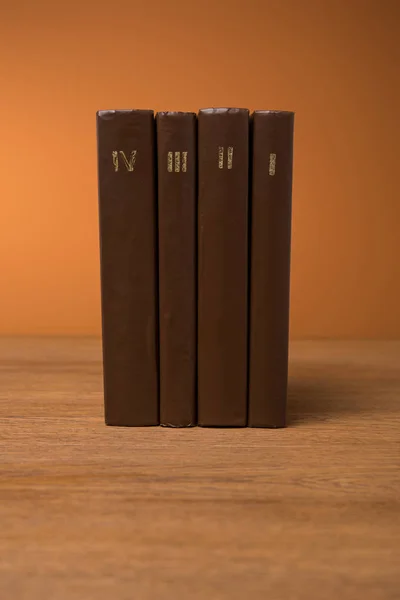 Volumi di libri antichi in pelle marrone copertine su tavolo in legno — Foto stock