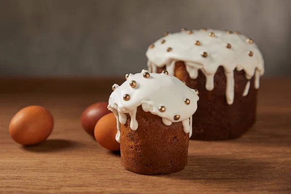 Bemalte Hühnereier und leckere Osterkuchen mit Streusel und Zuckerguss auf Holzoberfläche dekoriert — Stockfoto