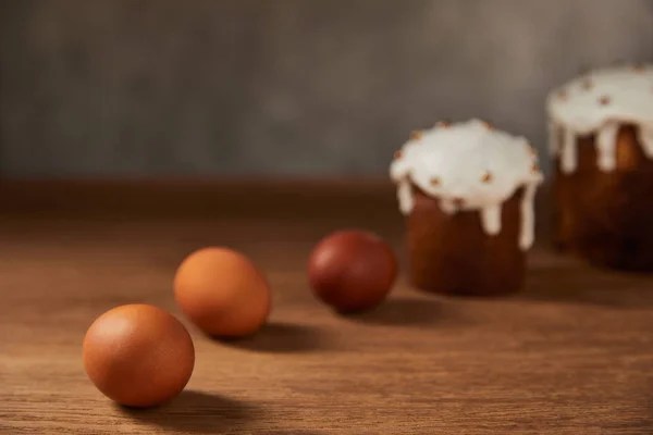 Messa a fuoco selettiva di uova di pollo dipinte e torte pasquali su tavolo di legno con spazio copia — Foto stock