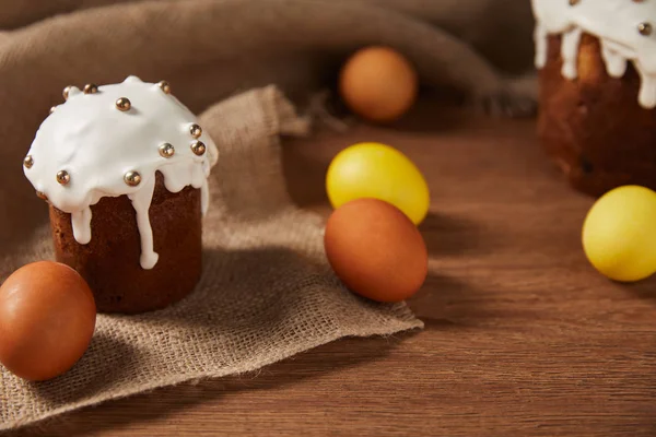 Uova di pollo dipinte e deliziosa torta di Pasqua decorata con spruzzi su sacco — Foto stock