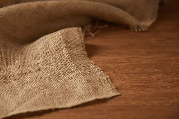 Fondo con tela de saco en superficie de madera con espacio de copia - foto de stock