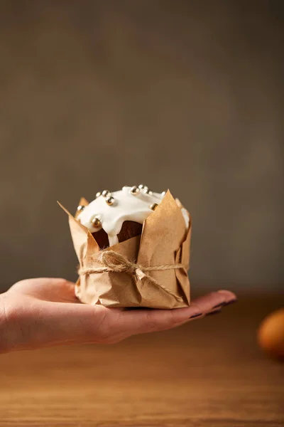 Vista ritagliata della donna che tiene tradizionale torta di Pasqua decorata con glassa e spruzzi — Foto stock