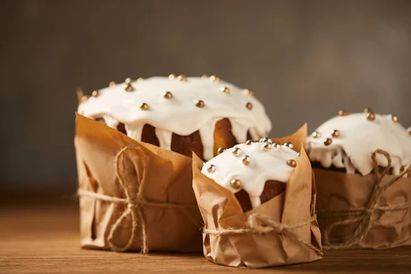 Deliciosos bolos de Páscoa com polvilhas e cobertura na mesa de madeira — Fotografia de Stock