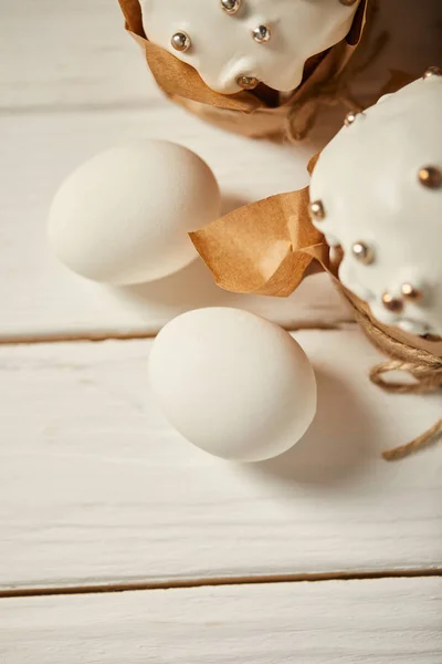 Top view of traditional easter cakes with chicken eggs on white wooden surface — Stock Photo