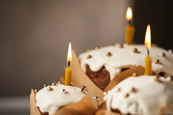 Selective focus of traditional easter cakes with sprinkles and burning candles — Stock Photo